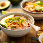 Slow cooker chicken taco soup topped with fresh cilantro and avocado