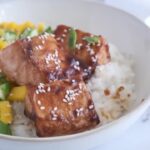 Teriyaki salmon with rice and mango in white bowl. Asian cuisine concept.